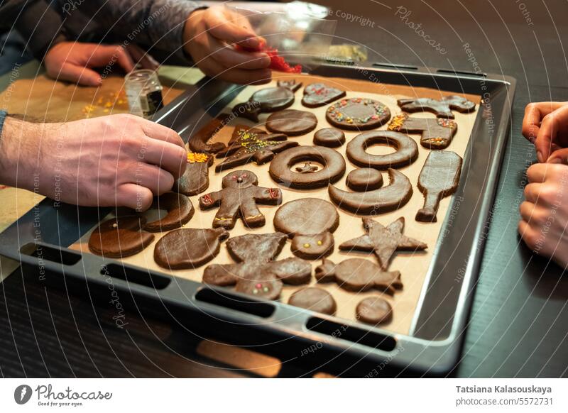 Eine Gruppe von Freunden bereitet vor Weihnachten Ingwerkekse in verschiedenen Formen zu Lebkuchenplätzchen Cookies Süßigkeiten Keks Süße Lebensmittel Dessert