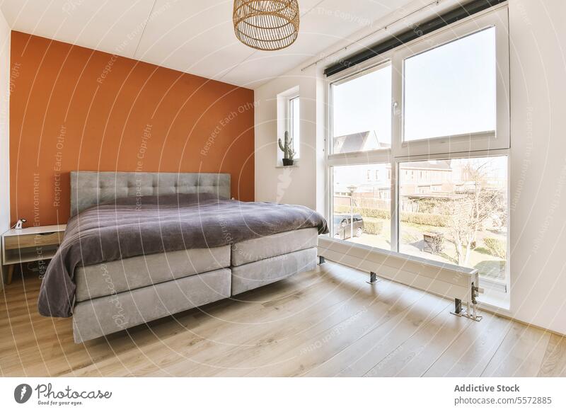 Modernes Schlafzimmer mit gemütlichem Bett und großem Fenster heimisch modern Glas durchsichtig Stock Decke Wand heimwärts Raum Design Innenbereich Möbel