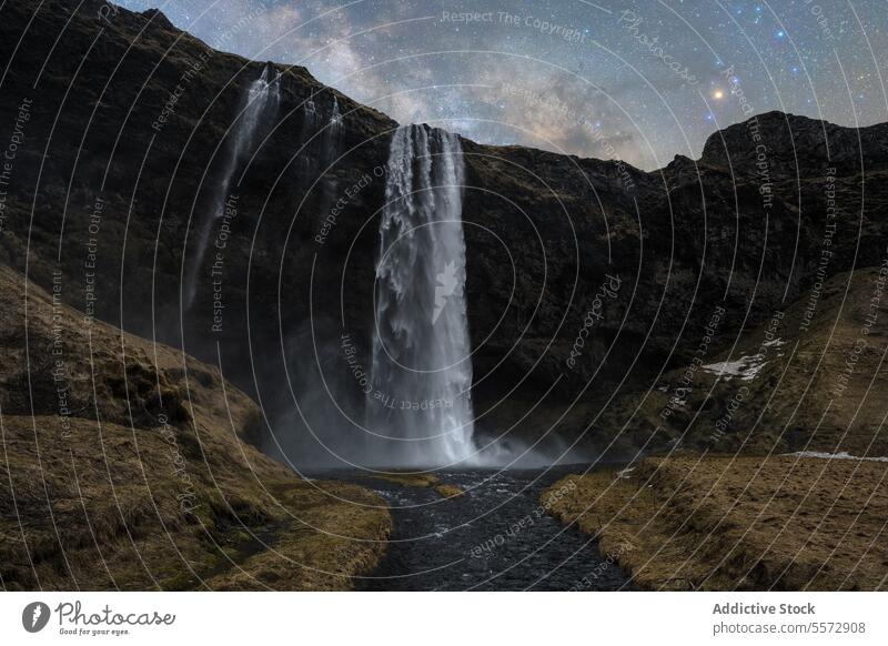 Kaskadenförmige Wasserfälle unter dem Sternenhimmel in Island Wasserfall Himmel Nacht Fluss Klippe dunkel felsig Gelassenheit Schönheit majestätisch himmlisch