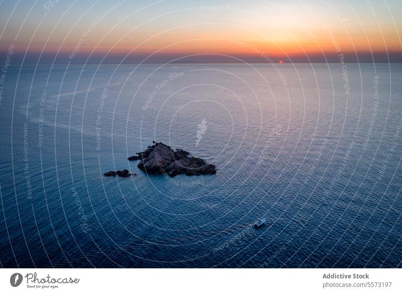 Felsklippeninsel im blauen Meer in Italien felsig Klippe Inselchen Rippeln Horizont Wolkenloser Himmel Sonnenuntergang Natur Isola Rossa Sardinien Europa