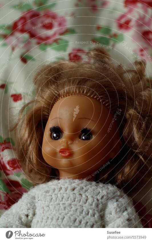 Eine alte Puppe liegt auf einem bunten Kissen Spielzeug Kindheit Mädchen schön Erinnerung Vergangenheit Vergänglichkeit Nostalgie Familie & Verwandtschaft