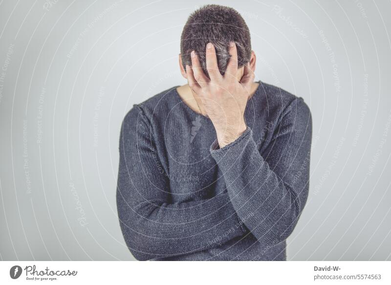 Kopfzerbrechen - Mann mit der Hand vor dem Gesicht kopfzerbrechen Verzweiflung Erschöpfung ratlos Kopfweh Kopfschmerzen Depression Burnout Stress Müdigkeit