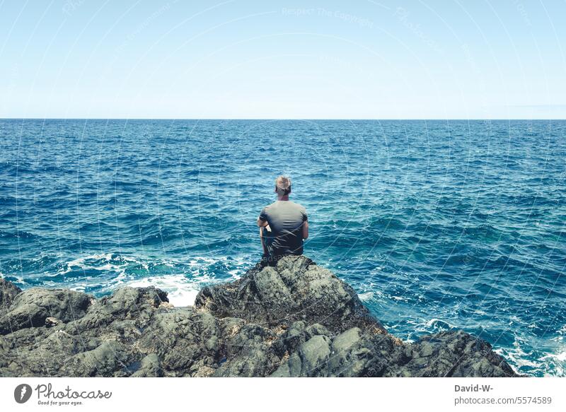 Mann schaut aufs Meer hinaus Ozean Ruhe Ferne Urlaubsort Reisen Küste Wasser Tourismus Ferien blau Erholung Freiheit Meeresrauschen türkis Rückansicht Sommer