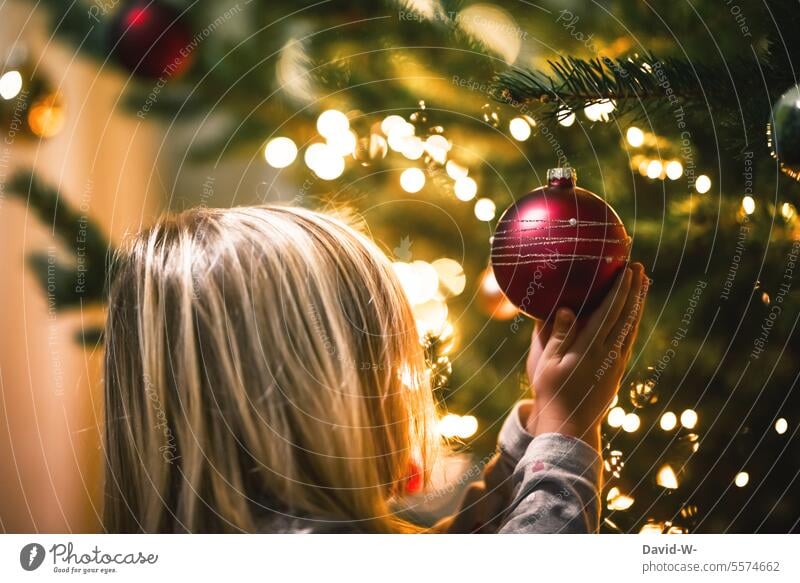 Kind beschaut sich eine Christbaumkugel am Weihnachtsbaum Weihnachten Erkunden Niedlich Vorfreude Staunen Baumschmuck Tradition festlich Ehrfurcht Vorsichtig
