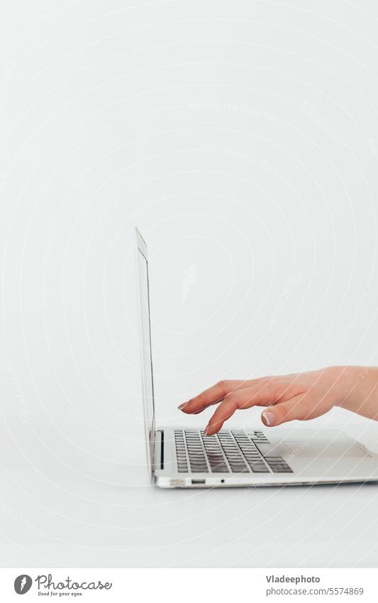 Weibliche Hand sorgfältig Tippen Tasten auf der Laptop-Tastatur, Seitenansicht, weißer Hintergrund, Minimalismus Computer Arbeit Business Presse Finger