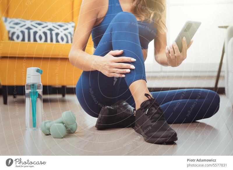 Frau beim Training. Workout zu Hause, Fitness zu Hause heimwärts Person Übung Yoga online Smartphone Tutorial Sport passen im Innenbereich schlank lebend Raum