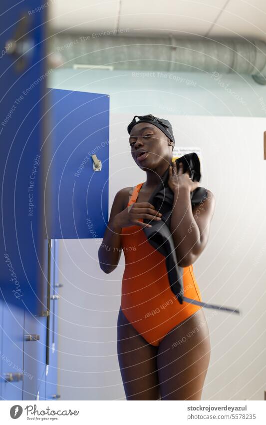 Schwarze junge Frau, die sich in der Umkleidekabine eines Schwimmbads abtrocknet Person Fitness Umkleideraum schwarz Schwimmer Handtuch Handtuchtrocknung