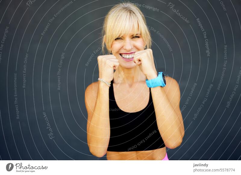 Lächelnde Frau beim Üben eines Kampfsport-Schlags im Fitnessstudio Bowle kämpferisch Glück stark Training selbstbewusst üben Aktivität physisch Stärke Wellness