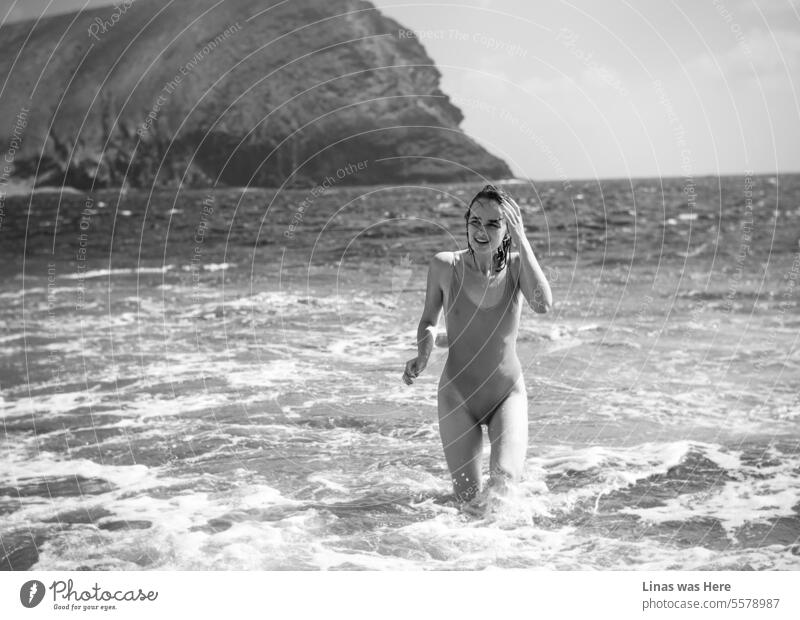 Ein wunderschönes Mädchen genießt ihren Urlaub und schwimmt im kristallklaren Wasser in der Nähe von La Montana Roja auf Teneriffa, Spanien. Ihr strahlendes Lächeln spiegelt die Freude wider, sich in ihrer eigenen Haut völlig frei zu fühlen. Eine hübsche Frau und ihre Urlaubspostkarte.