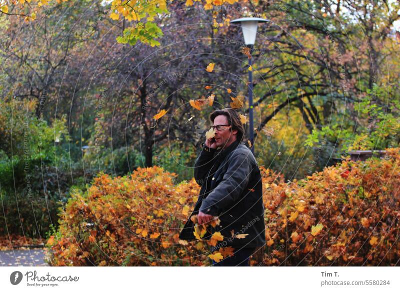 Mann telefoniert im Herbstlichen Park telefonieren Blätter Natur Baum Blatt fallen Herbststimmung Berlin Herbstlaub Laubwerk Herbstfarben Herbstfärbung