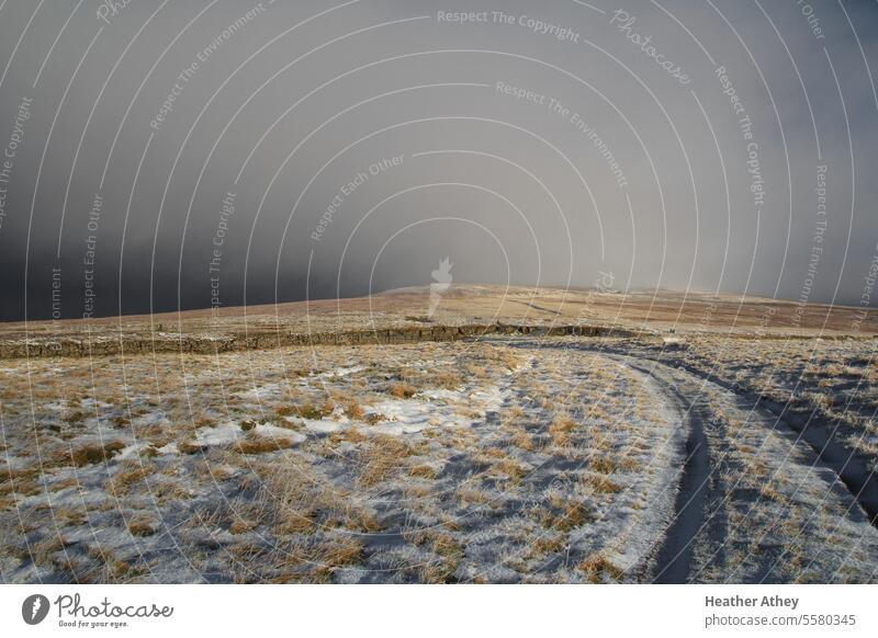 Schneeschauer auf einem Moorweg in Cumbria, Großbritannien Unwetter Gewitterwolken Wetter Winter Hügel Maure Moorland England Spuren Außenaufnahme Natur