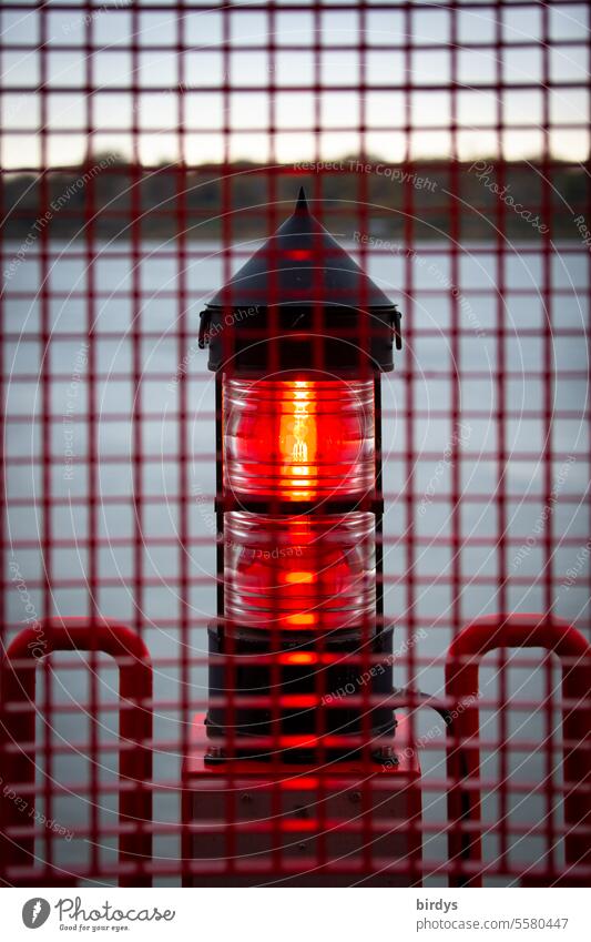 vergittertes rotes Positionslicht an der Elbe Schifffahrt Sicherheit Sichtbarkeit rotes Licht nautisch Wasser leuchtfeuer ufer Leuchtfeuer Gitter leuchten