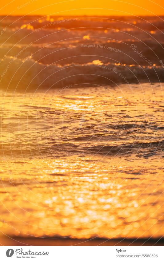 Sonnenuntergang über dem Meer. Natürliche Sonnenaufgang Himmel warmen Farben über Ripple Meer mit kleinen Wellen. Ozean Wasser Schaum plätschert. Schöne Meereslandschaft in Sonnenuntergang Sonnenaufgang Zeit