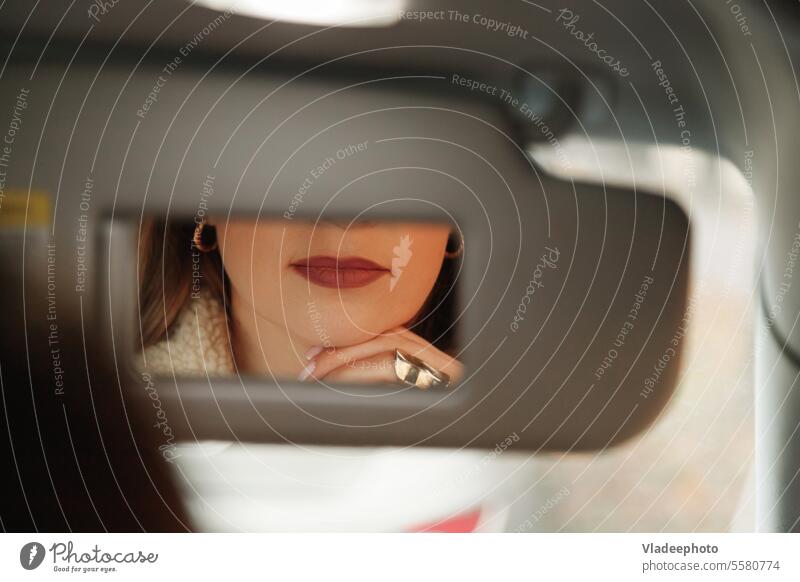 Eine Junge Mittelaltrige Frau Schminkt Sich Mit Lippenstift Im Auto,  Während Sie in Einen Kleinen Spiegel in Einem Visier Schaut Stockfoto -  Bild von lippenstift, spiegel: 235628980