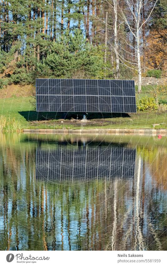 Sonnenkollektoren am Flussufer. Der Spiegel macht sie doppelt wirksam. solar Energie Elektrizität Batterie Sonnenenergie Erneuerbare Energie Fotovoltaik