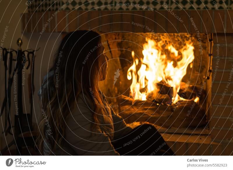 Latina Frau sitzt vor dem Kamin im kalten Winter Jugendzeit Armsessel Publikum brennend Weihnachtsbeleuchtung Weihnachtsschmuck bequem Textfreiraum gemütlich
