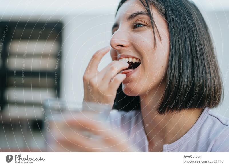 Frau lächelt, während sie viele Pillen in der offenen Hand hält, sie ist dabei, sie zu essen und zu ergänzen Tablette Ergänzung Glück Schmerztablette Vitamin