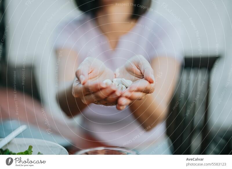 Nahaufnahme einer Frau, die viele Pillen in ihrer offenen Hand hält und sie der Kamera zeigt Tablette Ergänzung Glück Schmerztablette Vitamin Gesundheit Teilen