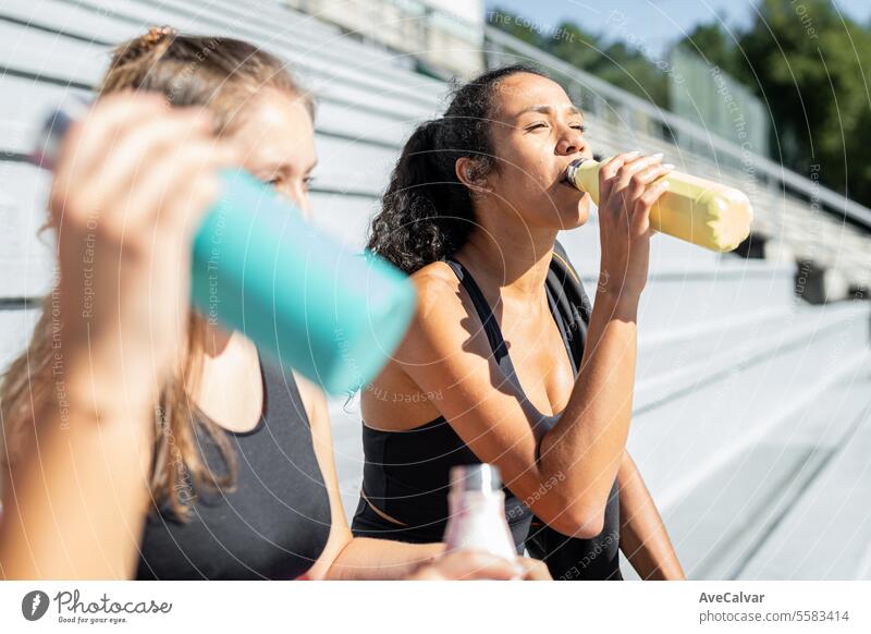 Mädchen trinkt nach dem Training Wasser aus einer Thermoskanne. Sie ruht sich vor einer weiteren Trainingsserie aus. Person Lifestyle Fitness Sport Gesundheit