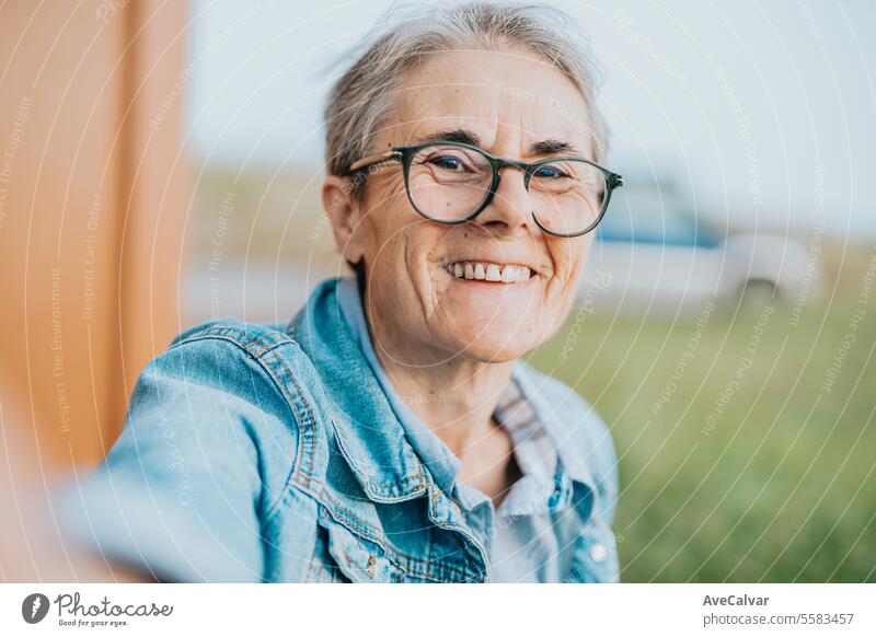 Ältere lächelnde Frau, die ein Selfie macht, während sie nach ihrer Pensionierung einen Ausflug macht und sich nach der Arbeit ausruht. mental Ruhestand Person