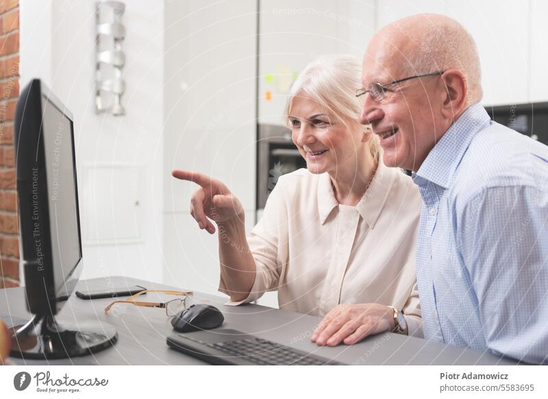 Glückliches älteres Paar genießt zusammen am Computer alt Menschen Senior Holunderbusch Laptop heimwärts Familie Person Hintergrund Internet Frau Mann Tisch