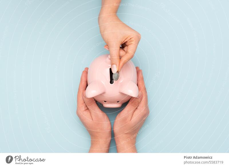 Frau legt eine Münze in ein Sparschwein. Konzept des Sparens Haushaltsplan Kontor Geld Einsparungen Schweinchen Bank finanziell flach legen Finanzen Kredit Mann