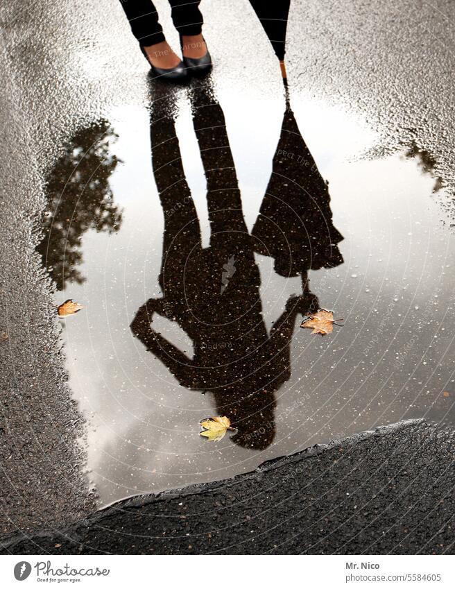 Regenpause Wetter Pfütze Reflexion & Spiegelung Schatten Silhouette Wasser Herbstlaub Regenwasser Jahreszeiten nass stehen Wege & Pfade Regenschirm Schuhe