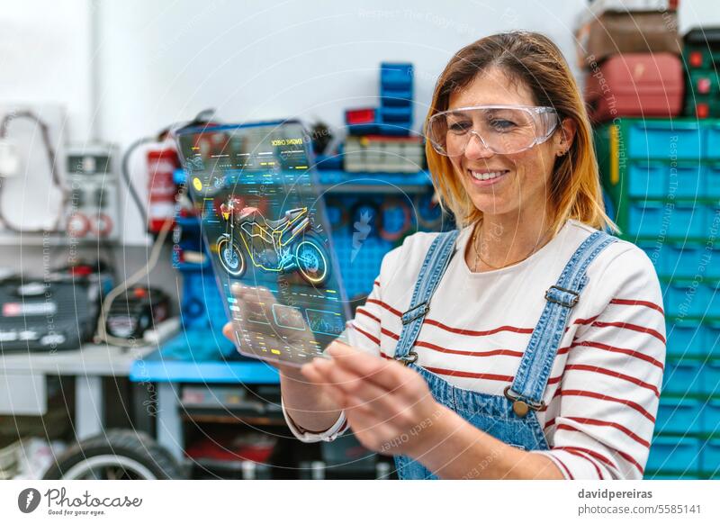 Mechanikerin mit transparentem Digital-Tablet und Motorrad-Diagnose-App Frau Porträt benutzend Tablette Diagnostik Bildschirm Schnittstelle durchsichtig Lächeln