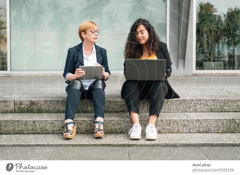 Senior und Junior Business Frau tragen Business-Kleidung, während Bindung zusammen. Büroangestellte Konzept im Freien Kollege Laptop jung Sitzen Computer