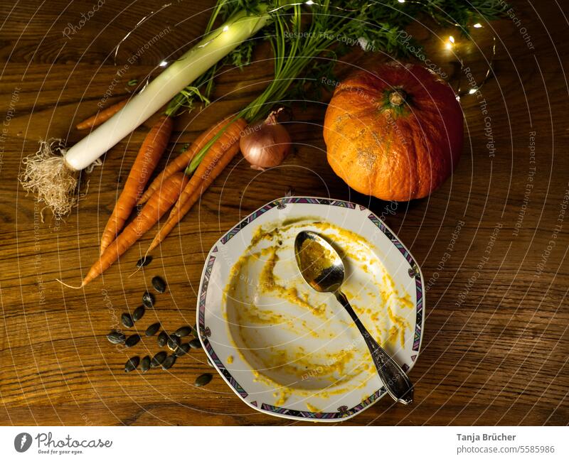 Leckere Kürbissuppe im Herbst hat geschmeckt. Leerer Teller und die Zutaten. leerer Teller aufgegessen satt es hat geschmeckt alles leer gut war´s satt gegessen
