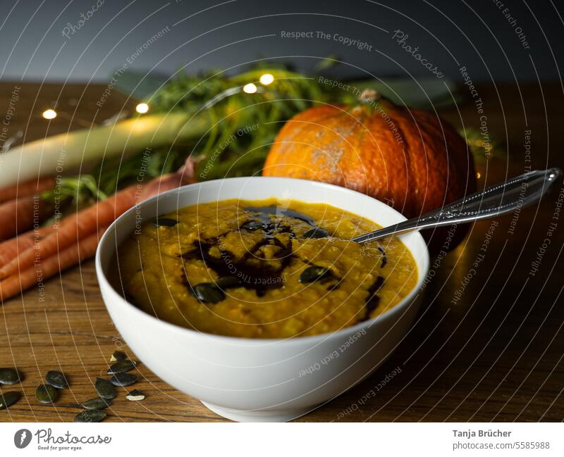 Leckere Kürbissuppe im Herbst mit Zutaten auf einem Holztisch Gemüse Vegetarische Ernährung vegetarisches Essen Gesunde Ernährung Erntedankfest saisonal