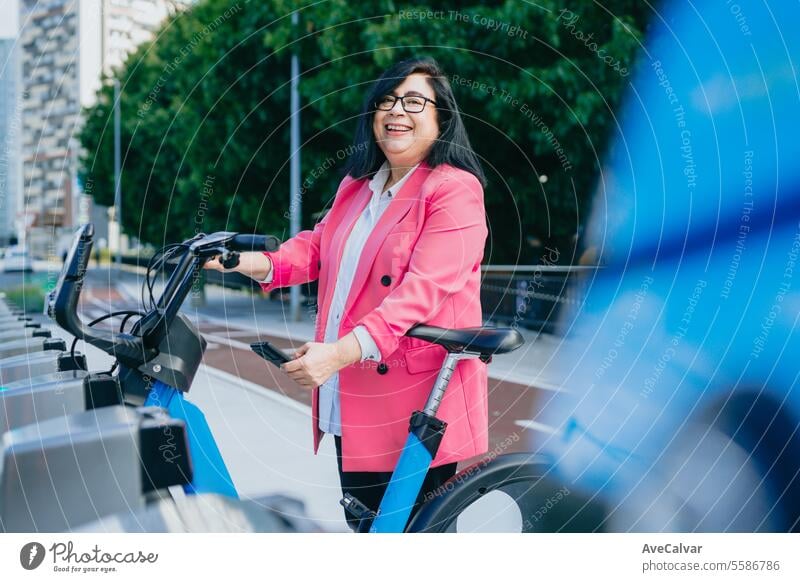 Aufgeregte Geschäftsfrau, die sich ein Fahrrad bei den öffentlichen Verkehrsmitteln mietet, um die Stadt frei zu erkunden. Radfahren Frau Frauen Straße Person