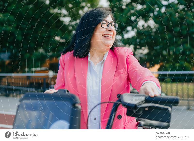Aufgeregte Geschäftsfrau, die sich ein Fahrrad bei den öffentlichen Verkehrsmitteln mietet, um die Stadt frei zu erkunden. Person Frauen Glück Porträt Lächeln