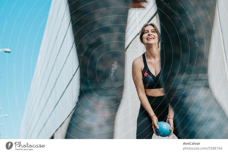 Junges Mädchen, das mit einem Medizinball trainiert, um die Muskeln im Freien zu stärken. Gesundes und sportliches Leben. Frauen Person urban Freunde Training