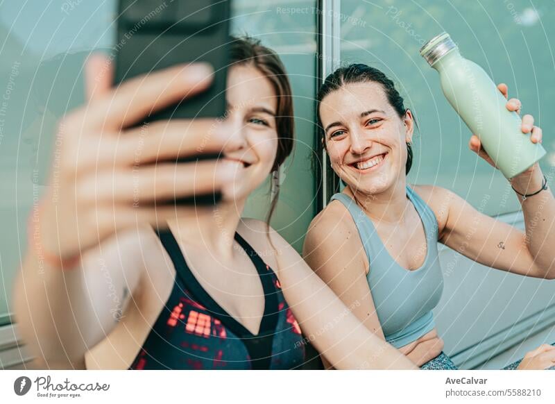 Ein paar glückliche Freunde, die ihr Training für ihren Lieblingssport beendet haben und ein paar Selfies mit dem Handy machen. Frau jung Person Mobile