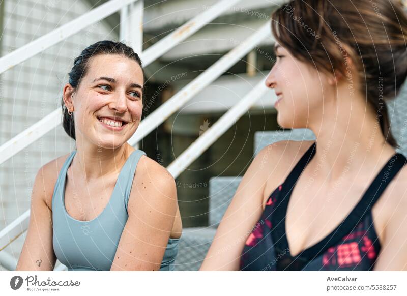 Zwei Freundinnen unterhalten sich fröhlich in Sportkleidung und sind bereit, gemeinsam Sport zu treiben und sich gegenseitig zu unterstützen. Lifestyle Frau