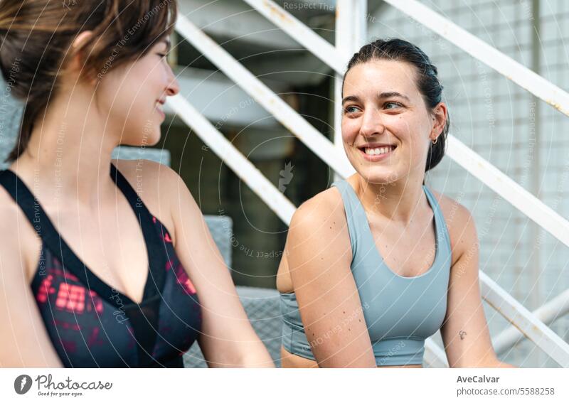 Zwei Freundinnen unterhalten sich fröhlich in Sportkleidung und sind bereit, gemeinsam Sport zu treiben und sich gegenseitig zu unterstützen. Fitness Gesundheit