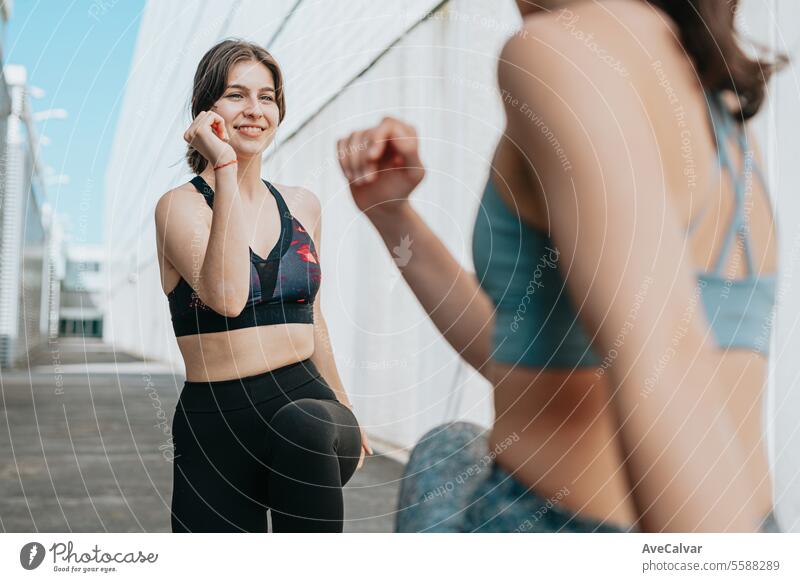 Junge Frauen, die außerhalb des Hauses einige ausgeprägte Übungen machen, springen und ihre Muskeln trainieren. Sport Fitness Person Training passen Lifestyle