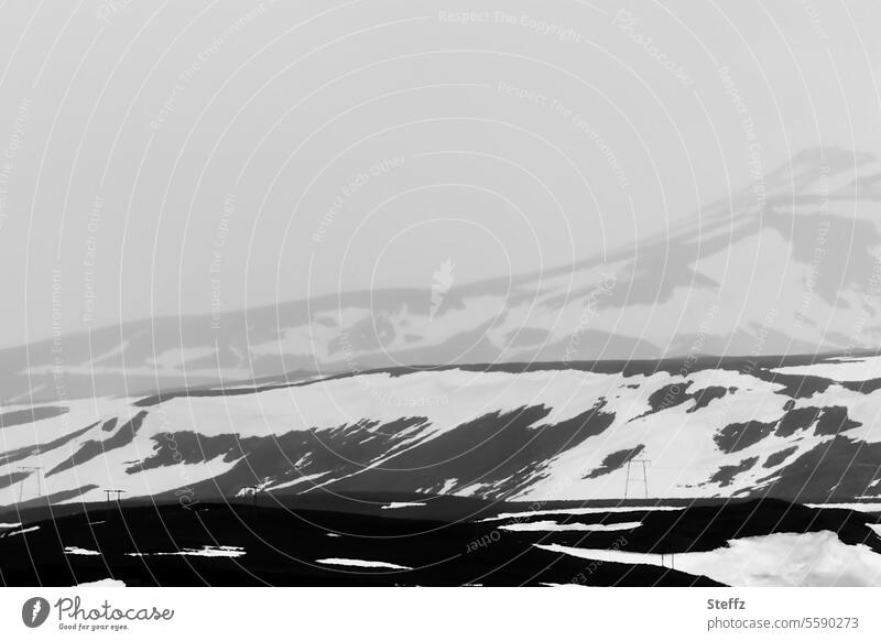 Blick auf ein Skigebiet auf Island Skilift Skipiste Skisaison Nebel nebelig Islandreise Nebelwand Hügel Berg Bergseite Hügelseite neblig Islandbild Ruhe dunkel