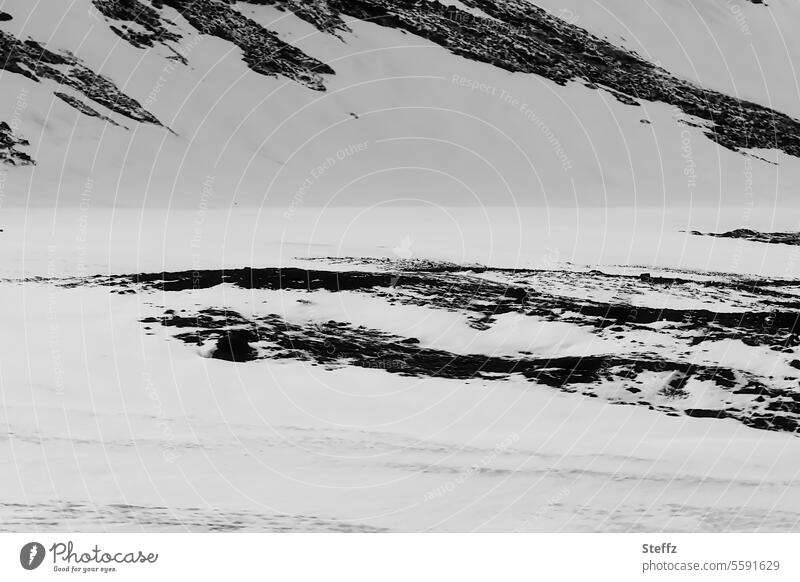 Blick auf verschneite Hügelseite auf Island Islandreise isländisch Wetter Klima Islandbild Ostisland Nordostisland Ruhe dunkel geheimnisvoll Berg Bergseite