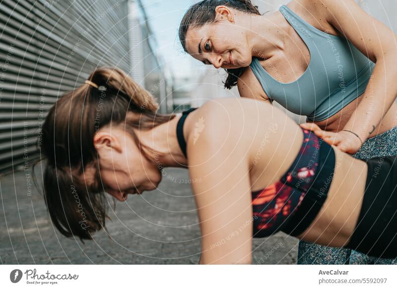 Zwei Freunde erläutern Übungen zur Stärkung der Muskeln. Die Freundschaft unterstützt und motiviert. Fitness Training Sport im Freien urban trainiert.