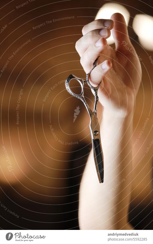 Friseurladen. Die Hand des Friseurs hält zwei verschiedene Arten von Scheren. Barber professionelle Werkzeuge. Männlich Haarschnitt, Mode. Friseursalon, Haarschnitt und Rasur Hintergrund. Kleines Geschäft. Selektiver Fokus