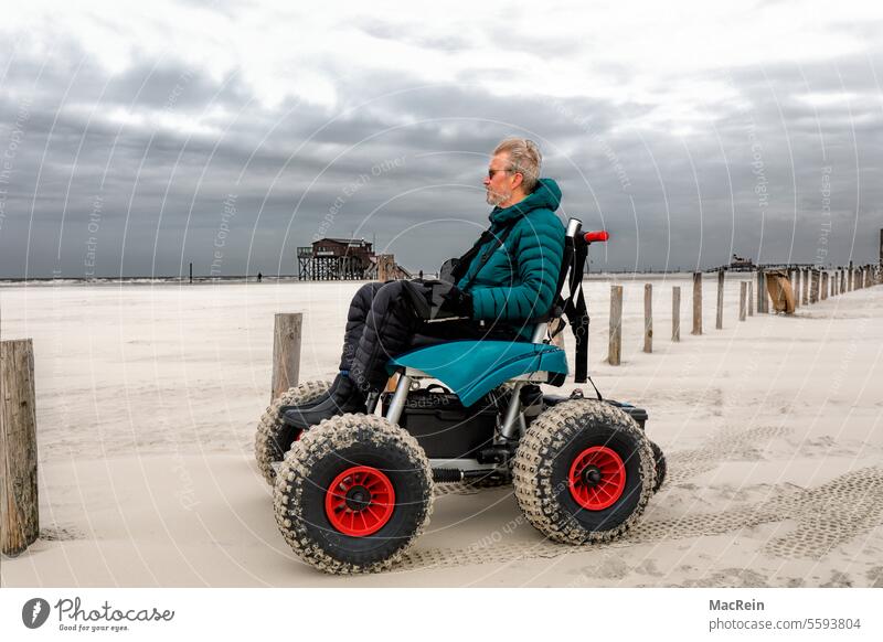 Mann im Strand-Rollstuhl, genießt den Strandurlaub Abenteuer Aktivität Allein Außenaufnahme Behindert Behinderter Energie Erholung Erwachsener Ferien Fernweh