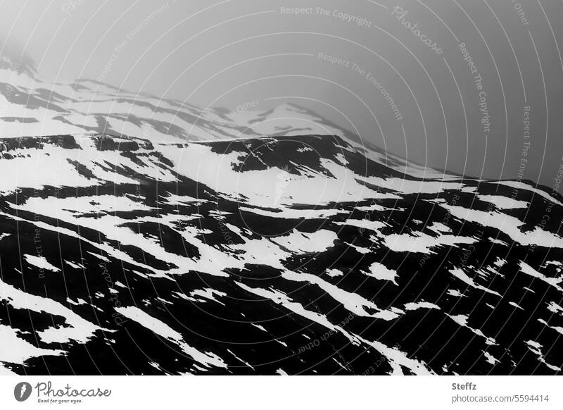 Blick auf eine felsige Hügelseite auf Island Islandreise isländisch Wetter Klima Islandbild Ostisland Nordostisland Ruhe dunkel geheimnisvoll Bergseite