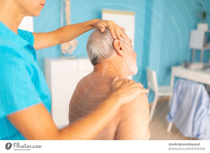 Eine Physiotherapeutin führt Dehnübungen am Nacken ihres Patienten, eines älteren Mannes, durch, um seine Rehabilitation und sein Wohlbefinden zu fördern Hals