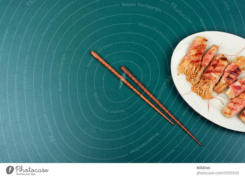 Enoki-Pilz-Rolle mit Speck gebraten als Vorspeise rollen gegrillt eingewickelt asiatisch Lebensmittel Enokitake Chinesische Essstäbchen Textfreiraum