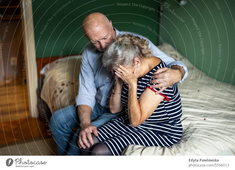 Älterer Ehemann tröstet seine depressive Frau zu Hause echte Menschen Senior reif männlich Mann Paar Zusammensein älter heimwärts alt Alterung Rentnerin