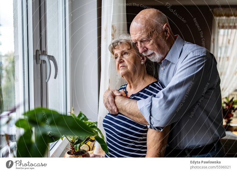 Porträt eines älteren Paares, das zu Hause aus dem Fenster schaut echte Menschen Frau Senior reif männlich Mann Zusammensein Kaukasier heimwärts alt Alterung