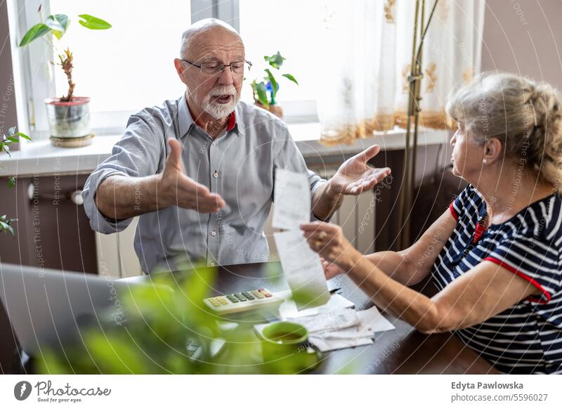 Älteres Ehepaar, das am Tisch sitzend die Finanzen seines Hauses bespricht echte Menschen Frau Senior reif männlich Mann Paar Zusammensein Kaukasier älter