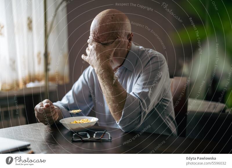 Depressiver älterer Mann frühstückt allein zu Hause echte Menschen Senior älterer Erwachsener reif männlich Kaukasier heimwärts alt Alterung häusliches Leben